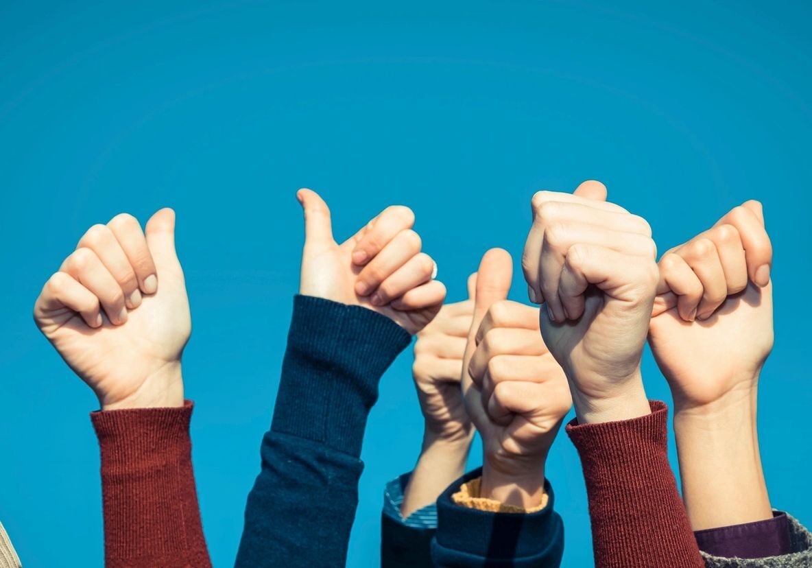Multiple diverse hands giving thumbs up